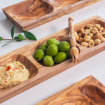 Three Apero wood platters made in Tunisia serving hazelnuts, humus and Castrelvetrano olives