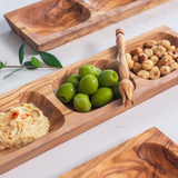 Three Apero wood platters made in Tunisia serving hazelnuts, humus and Castrelvetrano olives