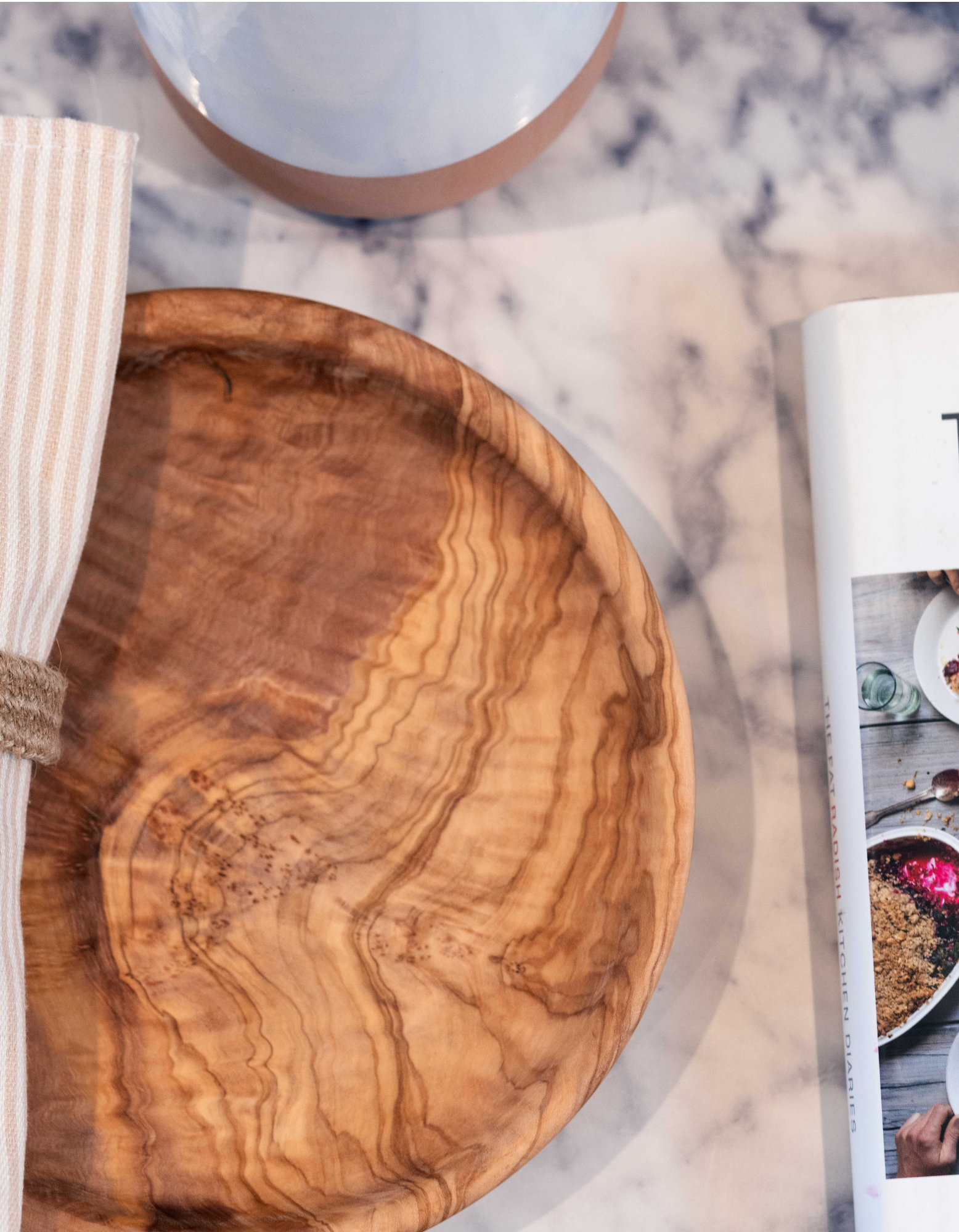 Olive wood plate on a marbled table set up