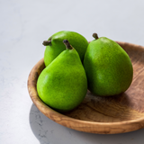 Round olive wood plate handcrafted in Tunisia with three green pears 