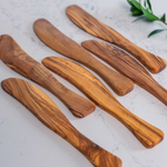 Assortment of aligned Spreader knives, in olive wood