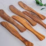 Assortment of aligned Spreader knives, in olive wood