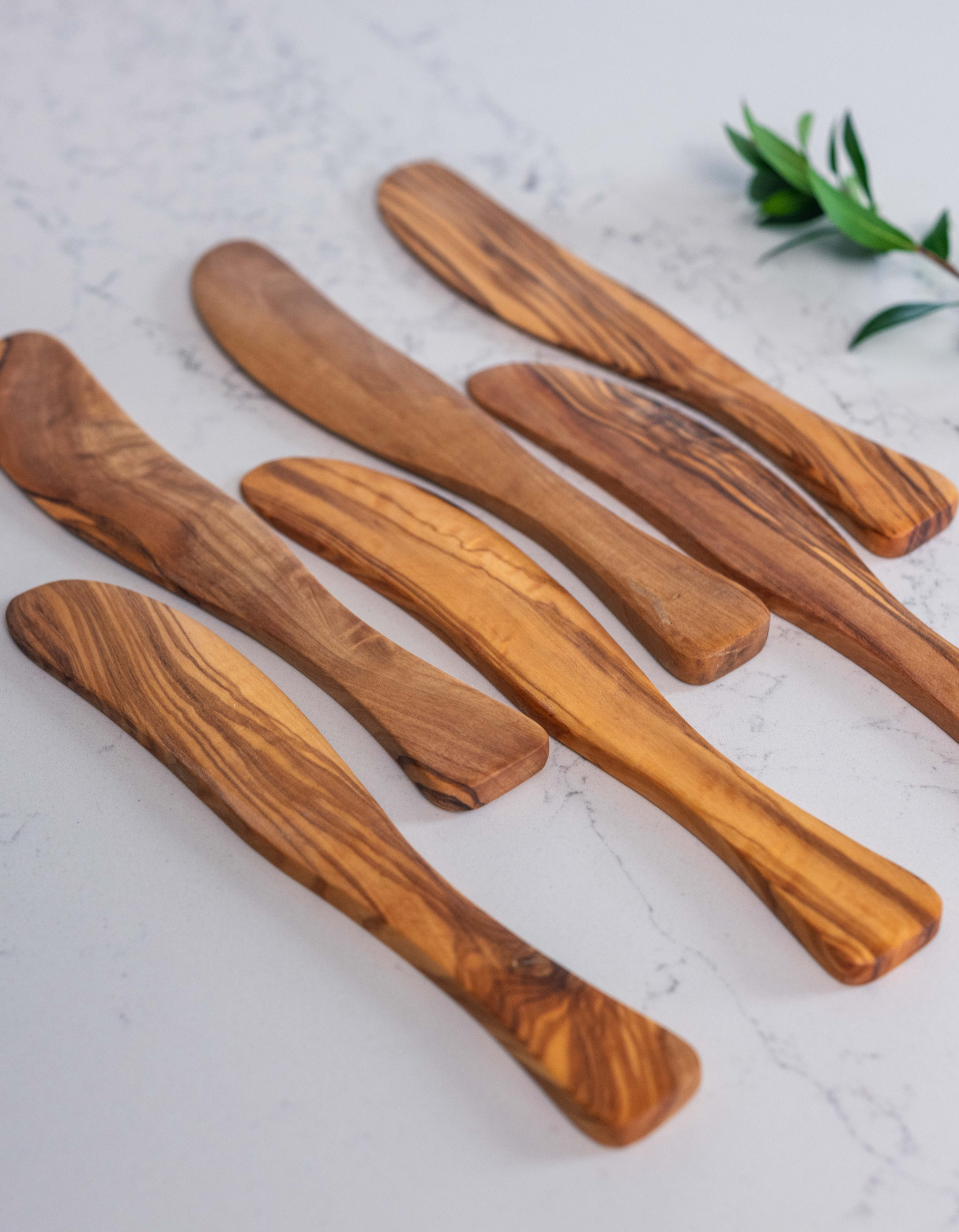 Assortment of aligned Spreader knives, in olive wood