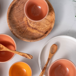 Assortment of ceramic bowl and wooden plate on white quartz countertop