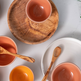 Assortment of ceramic bowl and wooden plate on white quartz countertop