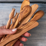 A hand full of olive wood utensils, handmade in Tunisia